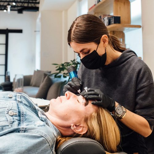 Eyebrows microblading concept. Cosmetologist preparing young woman for eyebrow permanent makeup procedure | Ella Esthetics in Alexandria, VA