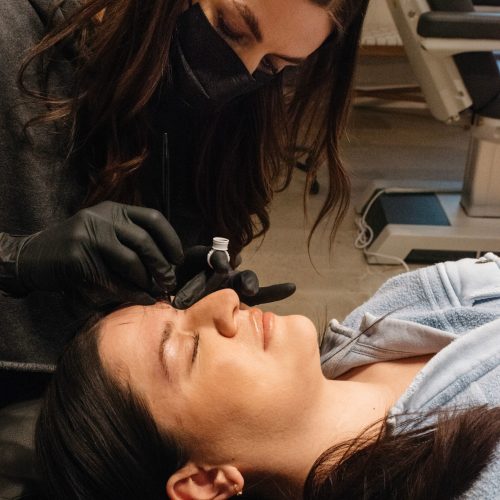 Eyebrows microblading concept. Cosmetologist preparing young woman for eyebrow permanent makeup procedure | Ella Esthetics in Alexandria, VA