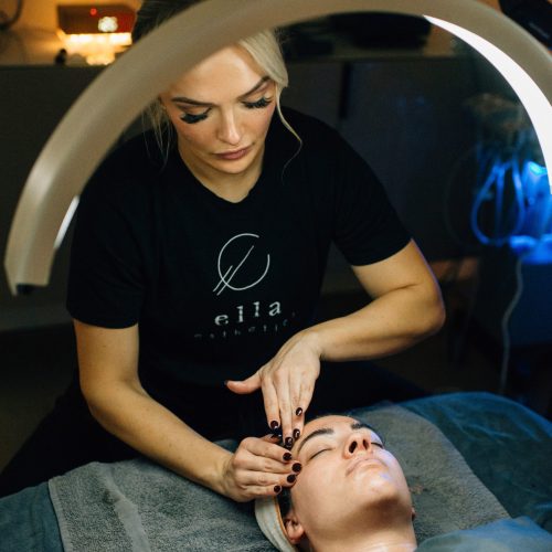 Doctor examining patient by touching forehead of woman in a clinic | Ella Esthetics in Alexandria, VA